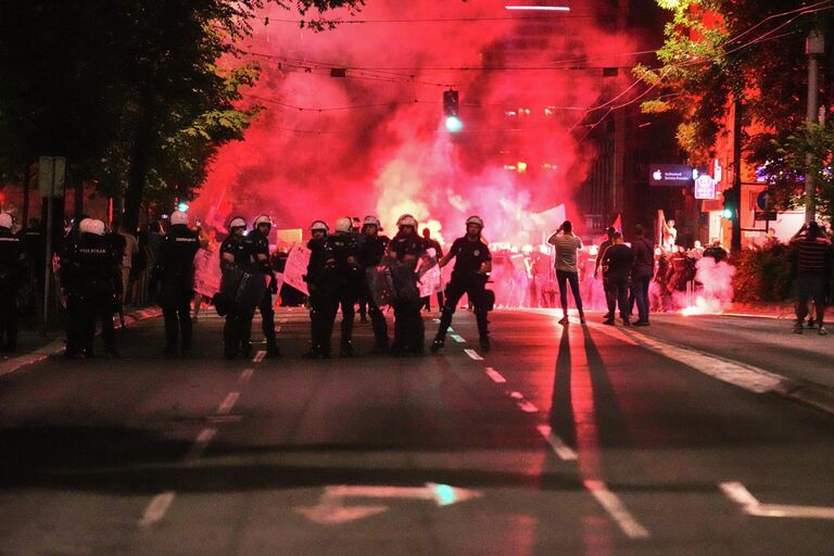 Полицейские блокируют улицу во время акции протеста в Белграде