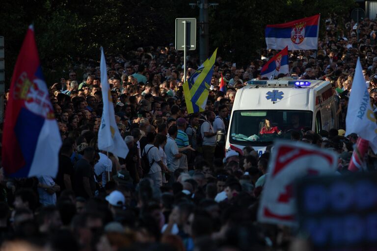 Машина скорой помощи едет во время акции протеста в Белграде