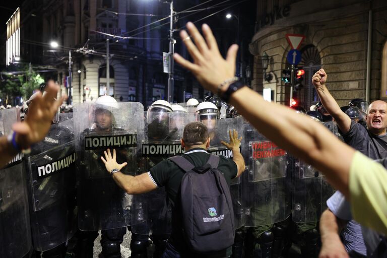 Полицейские блокируют улицу во время акции протеста в Белграде