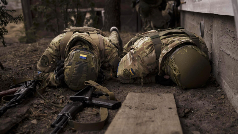 Украинские военнослужащие укрываются от артиллерийского огня